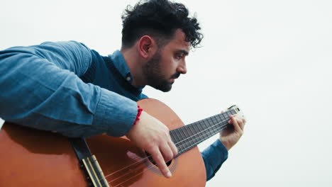 man practices arpeggios on guitar while playing outdoors