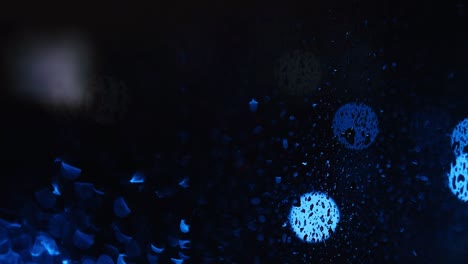 blue abstract background with drops on the glass, round light spots frame a chaotic pattern.