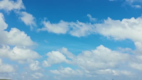 vertical pan from blue sky and clouds down to sand, looking from daymers bay out to stepper point and trebetherick point