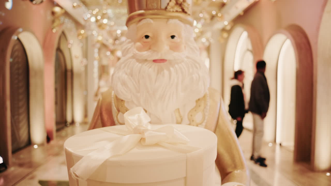 Close up of a Santa Claus figure inside a festive Christmas installation with warm lights and ornaments