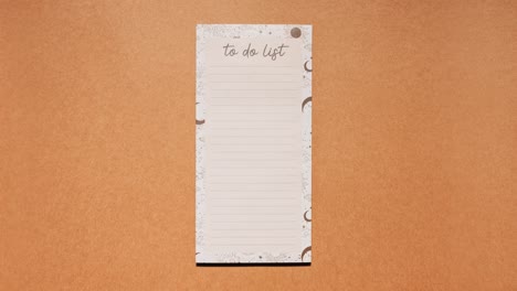 Stop motion of a lined to do list sheet sliding in and out on brown paper, loopable animation