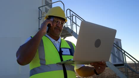 Männlicher-Ingenieur,-Der-Mit-Dem-Mobiltelefon-Spricht,-Während-Er-Einen-Laptop-4k-Benutzt