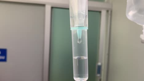 instalación médica de hidratación de líquido por goteo intravenoso en una clínica hospitalaria, cierre del goteo con mediciones de fluido
