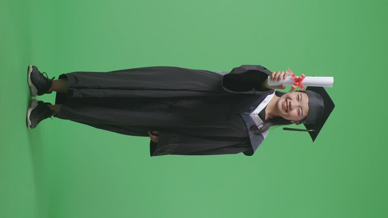Donna in toga di laurea che tiene un diploma