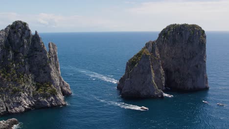 yates navegando alrededor del mar farallones formaciones rocosas en italia