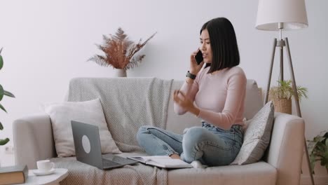 woman excitedly talking on phone while working from home