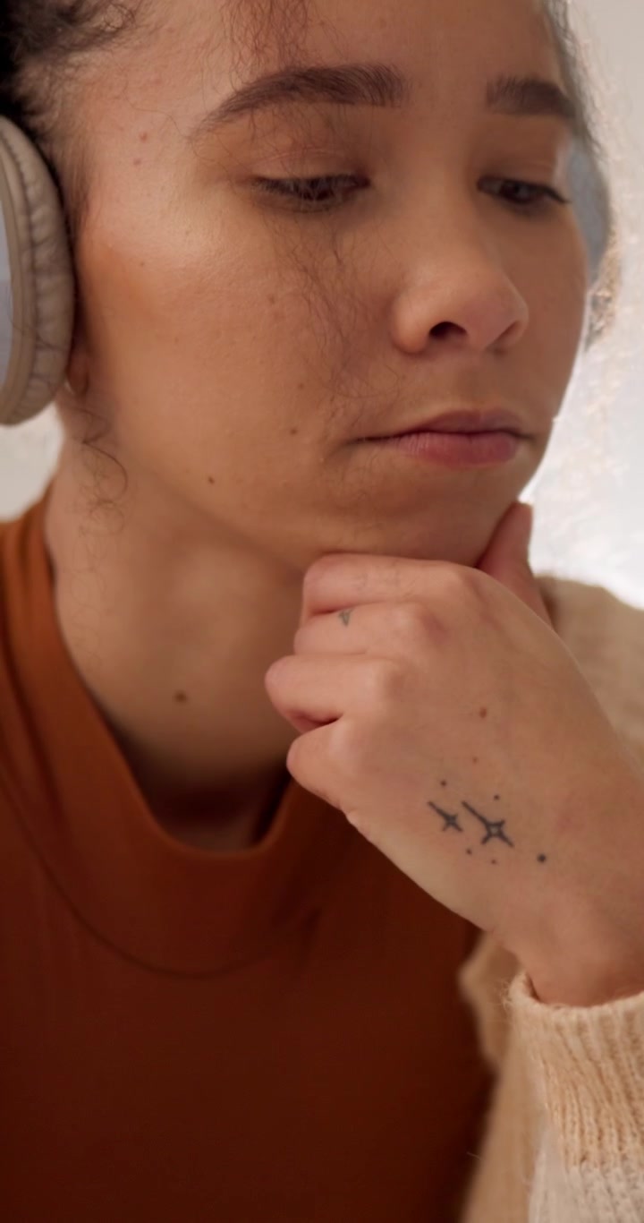 Giovane Donna con Cuffie che Pensa Guardando lo Schermo