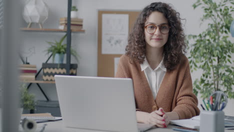 mujer trabajando en una computadora portátil en una oficina moderna