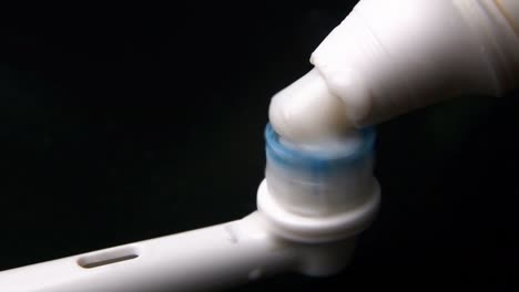 macro-video of the electric brush working and the application of toothpaste. a close-up shows the nozzle head, the villi of which move rapidly. oral hygiene concept