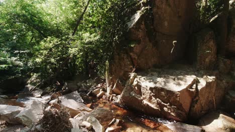 Man-climbing-over-the-rocks-at-the-falls-of-River-Riells