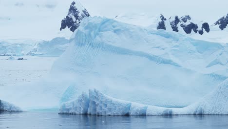 Gran-Iceberg-Enorme-Flotando-En-El-Océano,-Hermoso-Y-Dramático-Paisaje-De-Hielo-De-La-Antártida-En-Una-Escena-Costera-Azul-En-La-Costa-De-La-Península-Antártica,-Escena-Helada-Del-Mar-De-Invierno