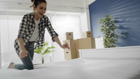 Tracking-video-of-happy-couple-putting-mattress-on-the-bed.