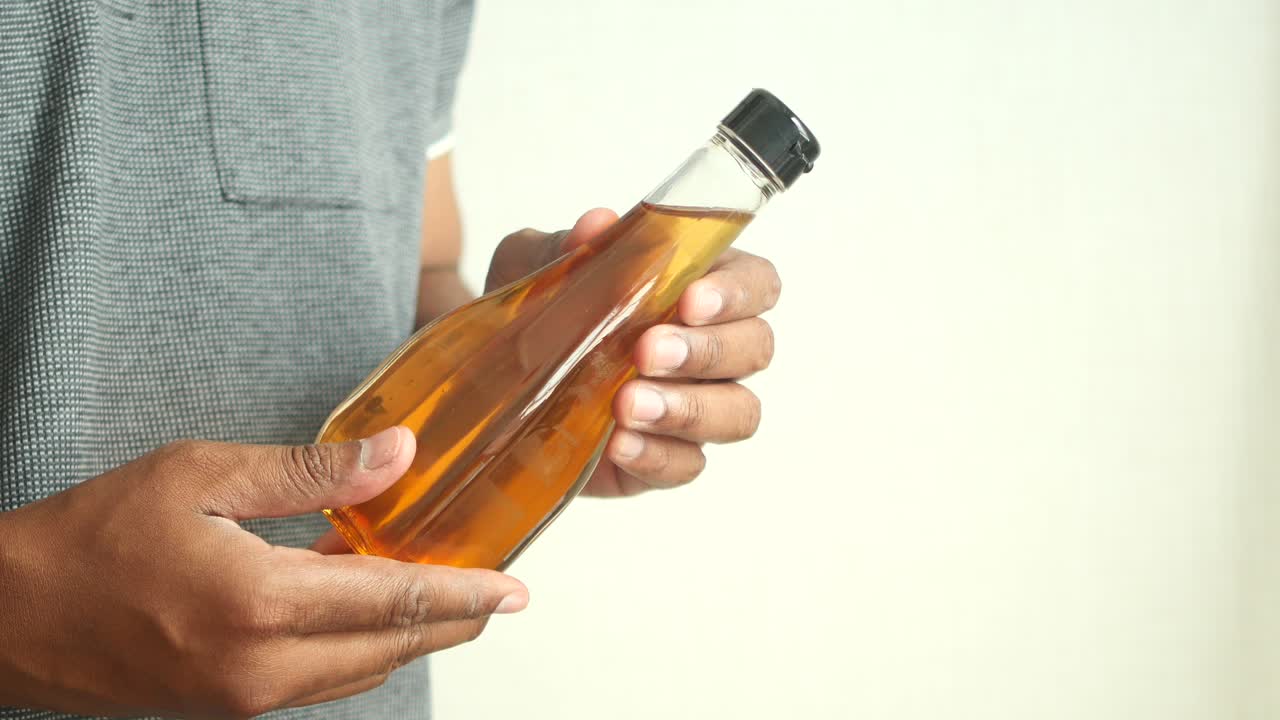 persona que sostiene una botella de aceite