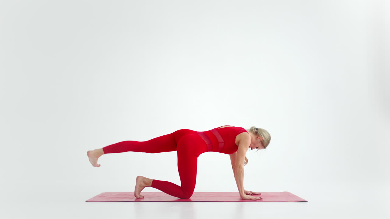Young woman shows yoga or pilates exercises. Young attractive woman practicing yoga in studio. Girl shows different poses for yoga in white background. Healthy lifestyle yoga in my heart sports