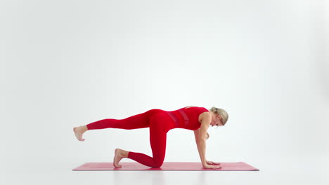young woman shows yoga or pilates exercises. young attractive woman practicing yoga in studio. girl shows different poses for yoga in white background. healthy lifestyle yoga in my heart sports