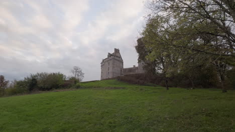 historic château du bouchet in rural france surrounded by green fields under a cloudy sky