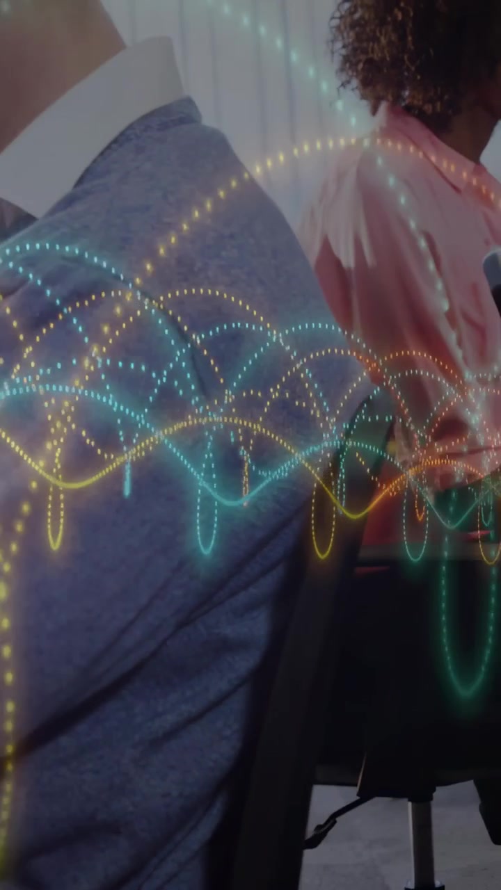 Vertical video: Team typing causing teal gold waves passing over torsos and chairs for business use