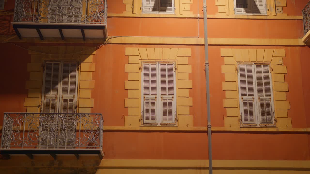 edificio naranja con persianas por la noche