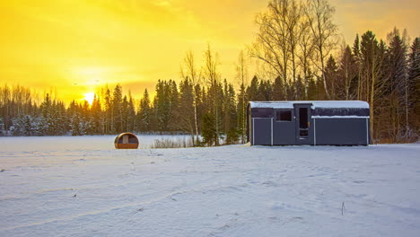 sustainable-hut-and-sauna-barrel-made-with-thermowood,-in-winter-boreal-woodland