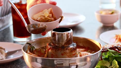 soup being served with seafood and vegetables