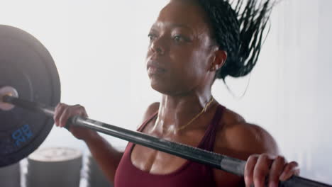 lifting barbell, woman focused on strength training in gym, wearing smartwatch