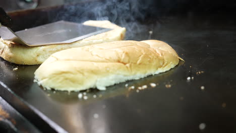 tostar un bollo de pan en la plancha superior plana para un sándwich - serie de camiones de comida