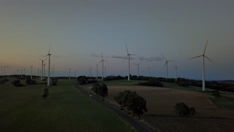 Drohnenaufnahme-über-Europäischem-Feld-Mit-Windrädern-Nach-Sonnenuntergang