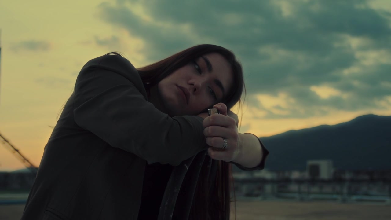 Jovem Mulher Segurando um Isqueiro Aceso ao Pôr do Sol