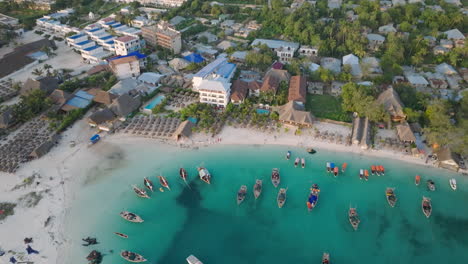 Aerial-view-of-wooden-fisherman-boats-and-sandy-beach-at-Kendwa-village,-Zanzibar,Tanzania