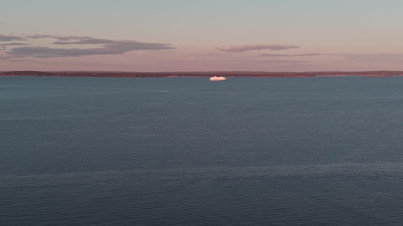 A serene shot of Oslofjord in Norway, with a distant Cruise ship on the horizon