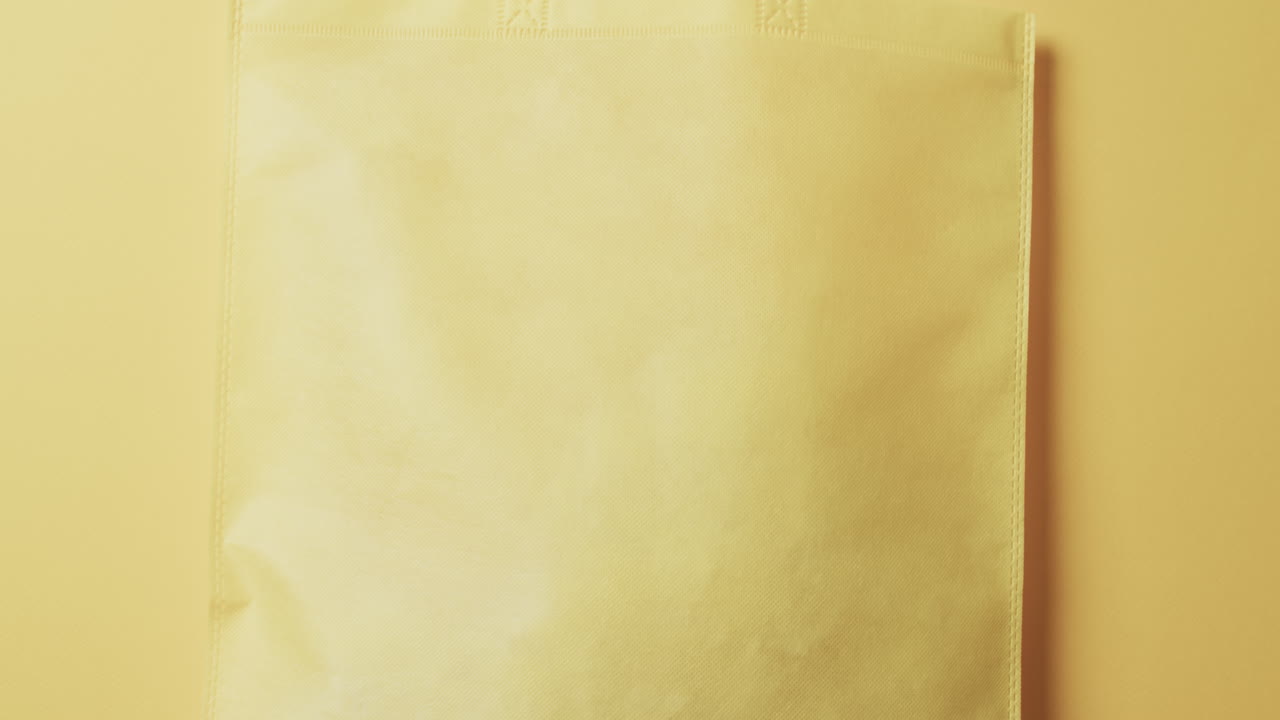 video de una bolsa de lona amarilla con espacio de copia en un fondo amarillo