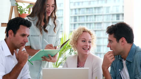 Casual-business-people-looking-at-laptop-computer-