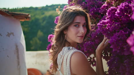 romantic brunette sniffing flowers aroma at windy summer portrait. woman posing