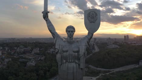 el monumento de la patria en kiev, ucrania en una puesta de sol - dron de alejamiento