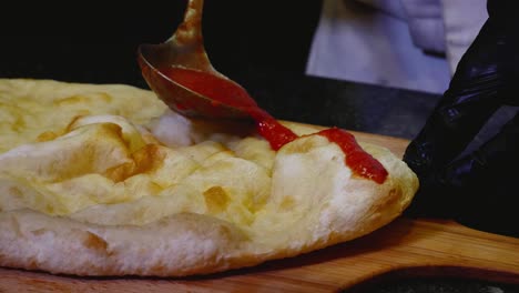 preparing pizza with tomato sauce