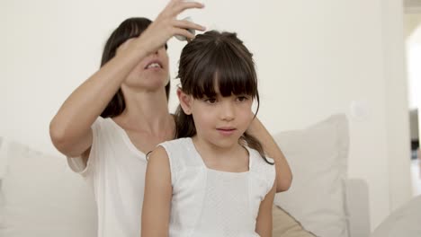 madre feliz pegando el cabello de sus hijas con un cierre de arco