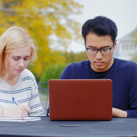 Studenten-Arbeiten-Mit-Einem-Laptop-Am-Tisch-Eines-Sommercafés