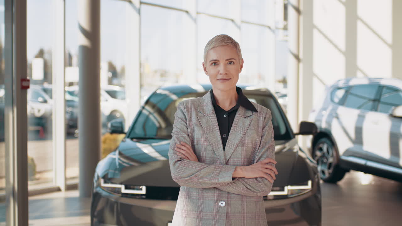 mujer delante de un coche en un concesionario de automóviles