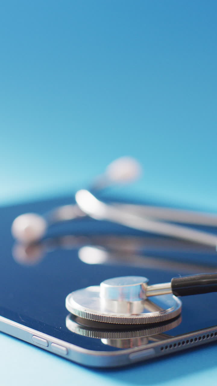 Video verticale di stetoscopio medico e smartphone su sfondo blu, con spazio per il testo