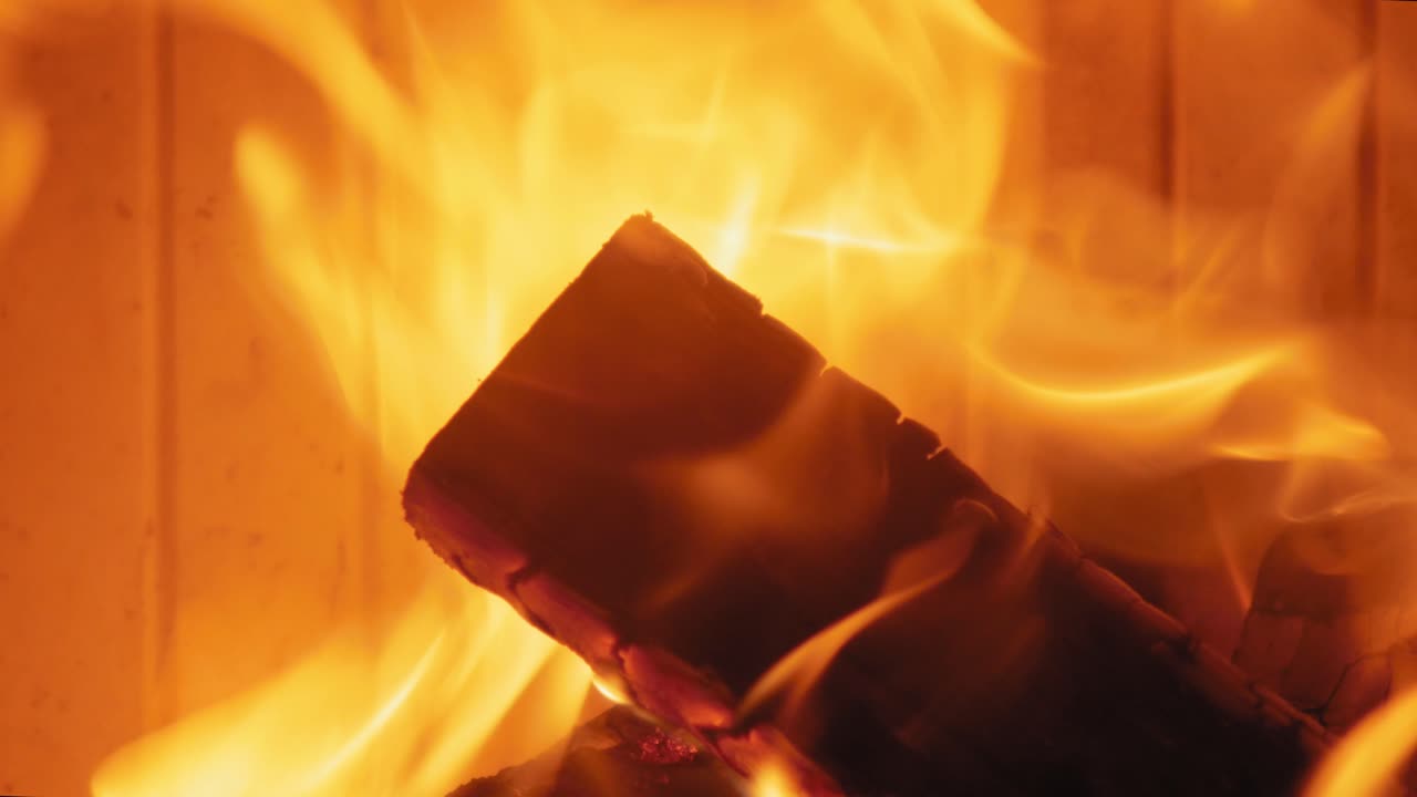 나무 통나무에 있는 벽난로에서 타는 불꽃