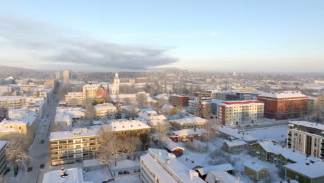 aerial flyover snowy streets, toward the downtown of kuopio, sunrise in finland