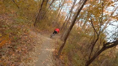 Fpv-drohne-Folgt-Mountainbiker-Durch-Waldweg-Während-Der-Herbstsaison