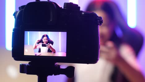 display camera of asian kid girl playing video game with mobile phone then celebrating while live stream
