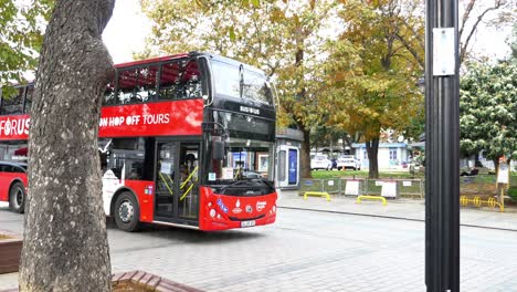 double-decker red hop-on hop-off sightseeing bus in city street