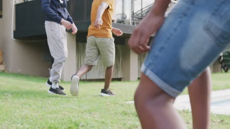 Felices-Amigos-Adolescentes-Varones-Diversos-Jugando-Al-Fútbol-En-El-Jardín,-Cámara-Lenta