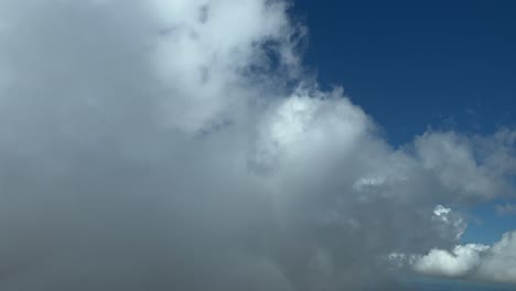 la perspectiva de un piloto: volando a través de algunas nubes cumulus esponjosas en una soleada tarde de verano