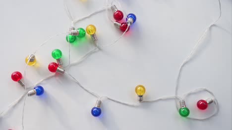 christmas led lights in blue, red, yellow, and green are arranged on a white surface, seen from above