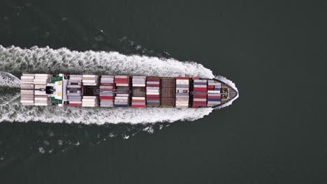 container ship in front of the port of vlissingen. aerial drone video. transport and logistics
