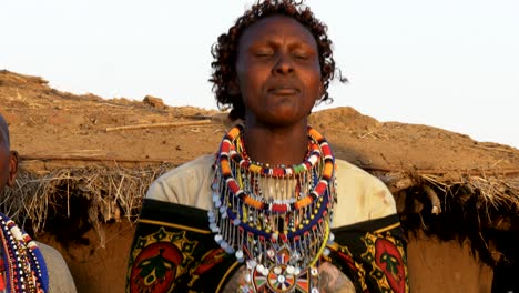 un primer plano de una mujer masai en verde cantando