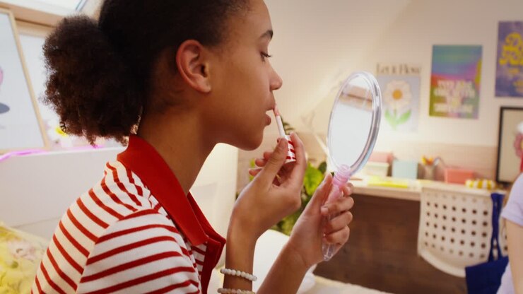 Ragazza adolescente che si mette il rossetto